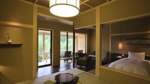 Una habitación de hotel con una cama, una mesita, una silla y vistas al exterior.