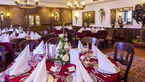 A banquet hall with round tables set for a formal event, featuring red tablecloths, white napkins, and silverware. - Hotel Alt Westerholt (Herten)