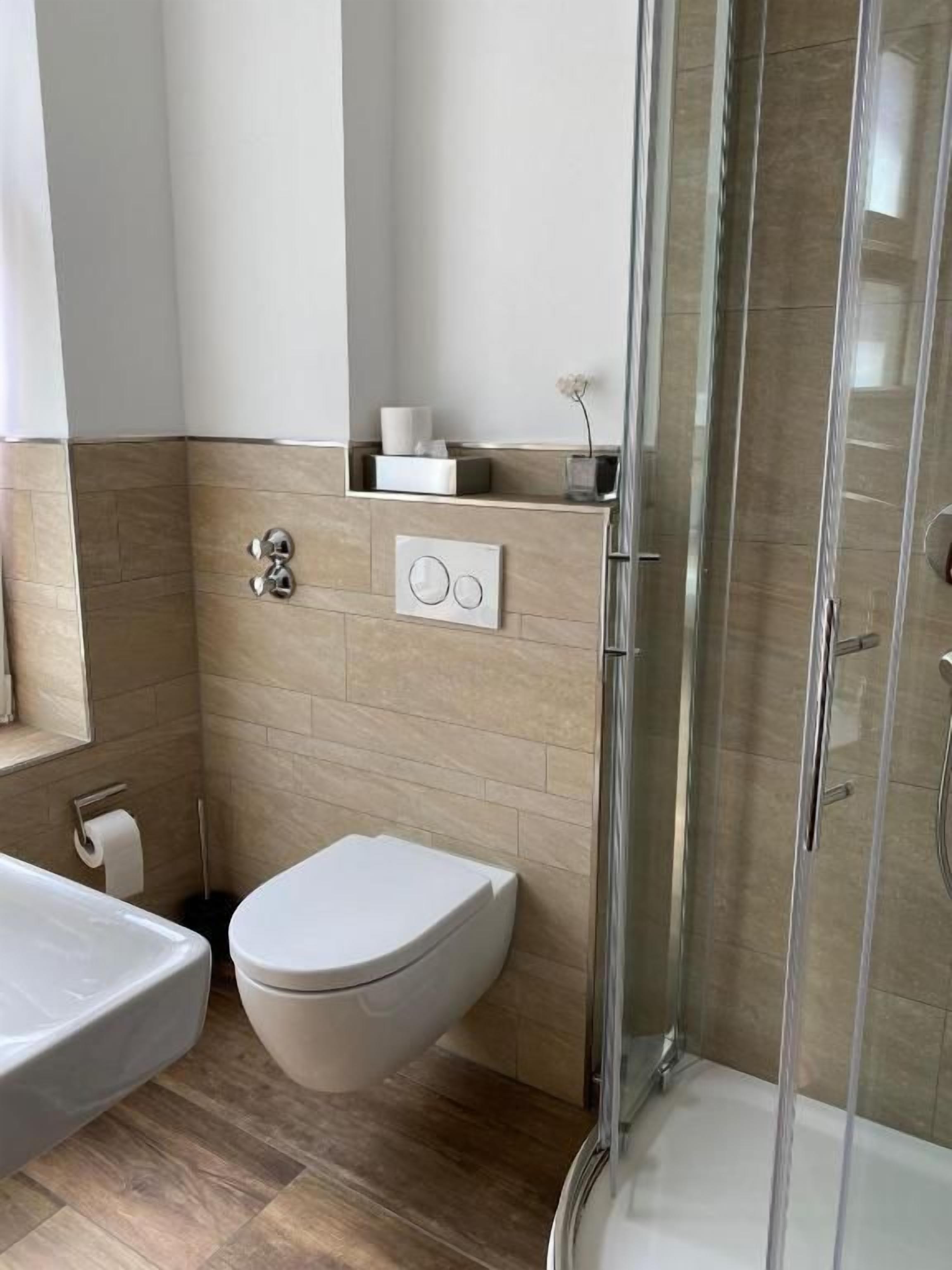 Une salle de bain moderne équipée de toilettes, d’un bidet et d’une douche.