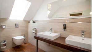 A modern bathroom with two sinks, a toilet, and a skylight. - Hotel Alt Westerholt (Herten)