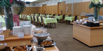 Ein reichhaltiges Buffet mit mehreren Tischen und einer Auswahl an Speisen, sowie einer Uhr an der Wand.
