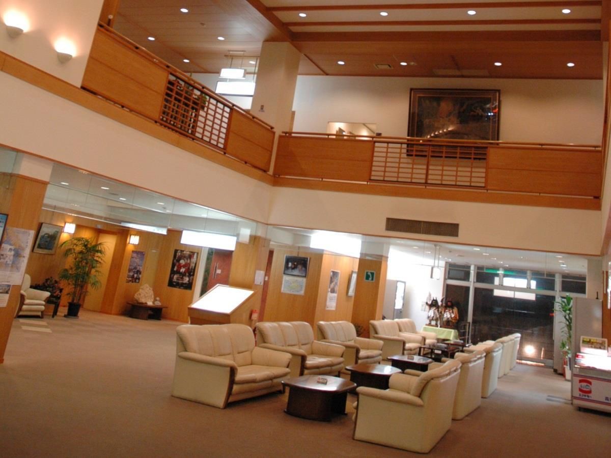 A spacious lobby with multiple seating areas, a staircase, and a reception desk.