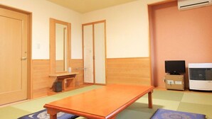 Une pièce avec une table en bois, un téléviseur, un climatiseur et des tatamis.