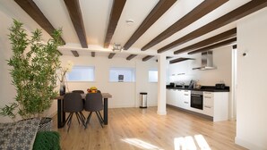 A modern kitchen with white cabinets, a black countertop, and stainless steel appliances.