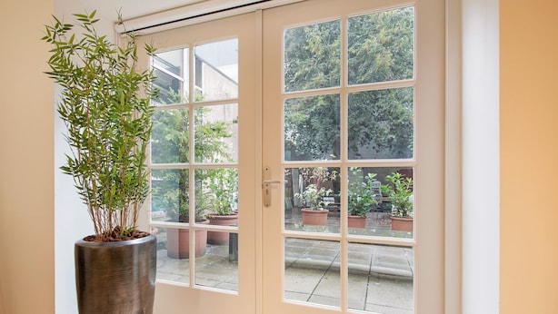 A room with a sliding glass door leading to a garden area.