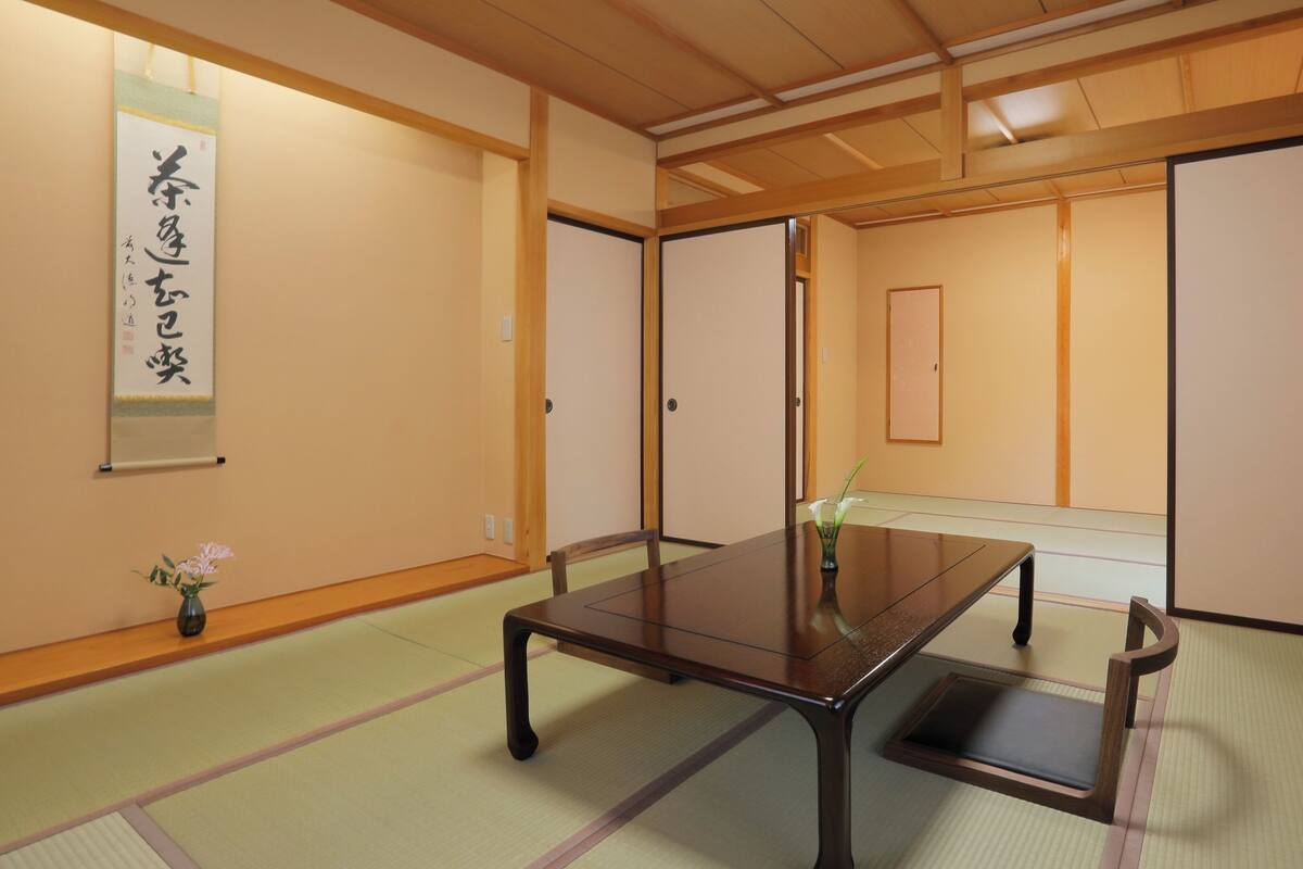 Een traditionele Japanse kamer met tatami vloerbedekking, een lage houten tafel en schuifdeuren.