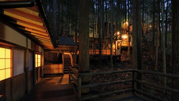 A wooden structure with a staircase leading to a platform, surrounded by trees.