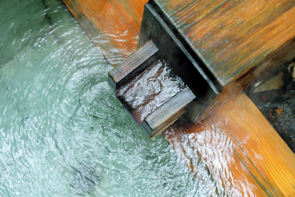Een detail van een houten constructie met een waterpartij, mogelijk onderdeel van een gebouw.