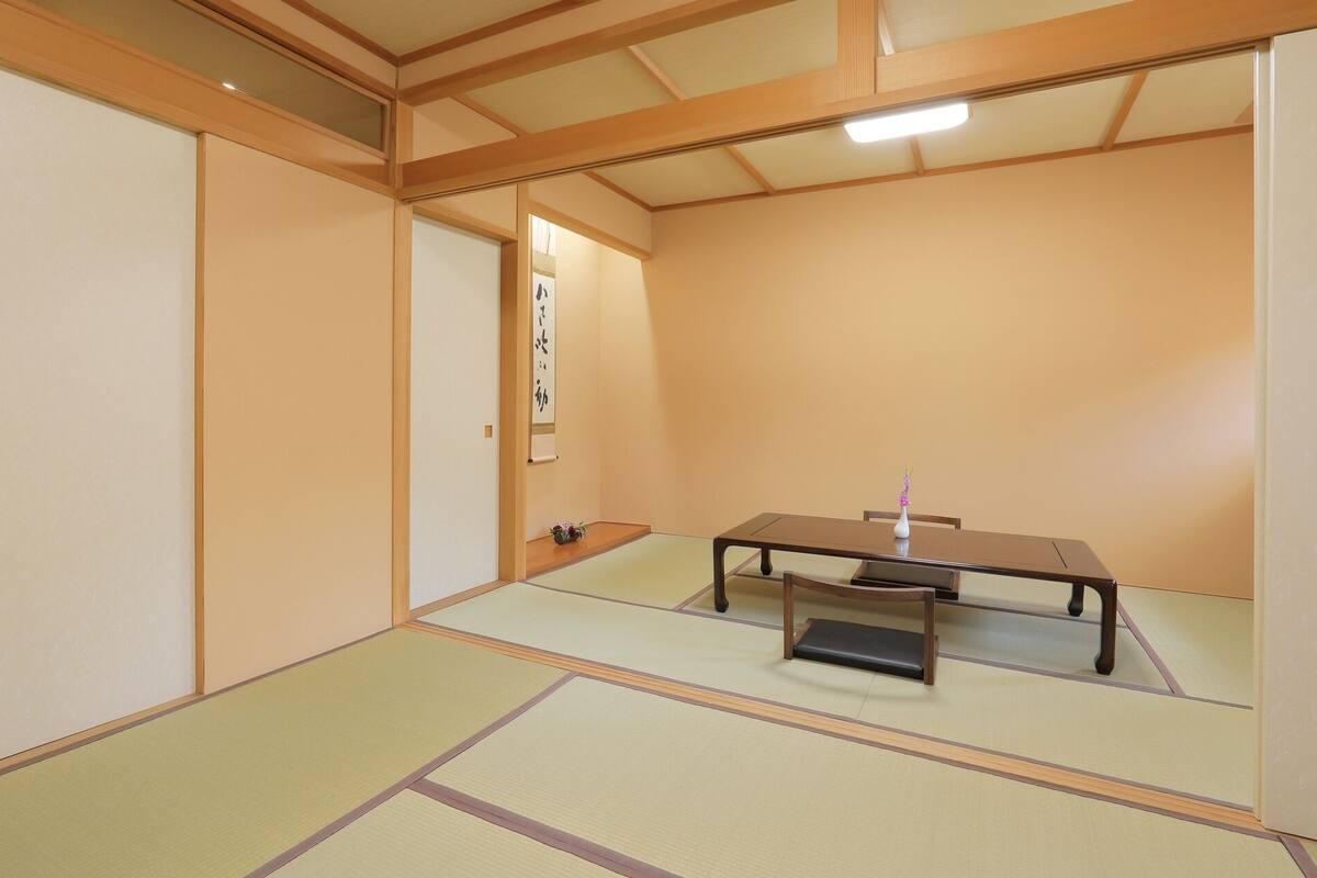 Een traditionele Japanse kamer met tatami vloerbedekking, een lage tafel en schuifdeuren.