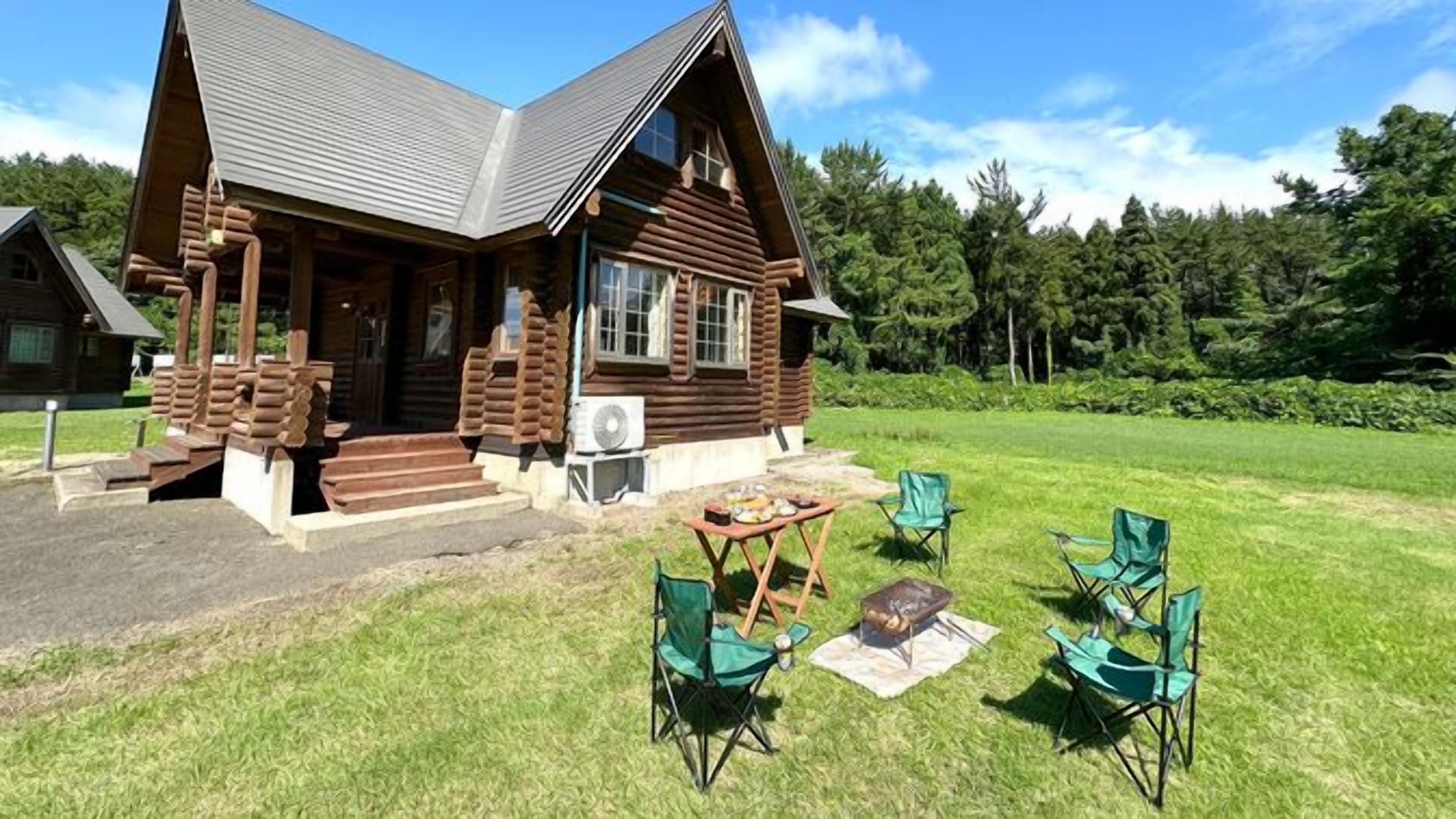 Une cabane en rondins avec un porche, un espace salon extérieur et un foyer.