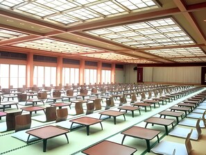 Un vaste hall doté de rangées de tables et de chaises, de grandes fenêtres et d’un haut plafond agrémenté de lucarnes.