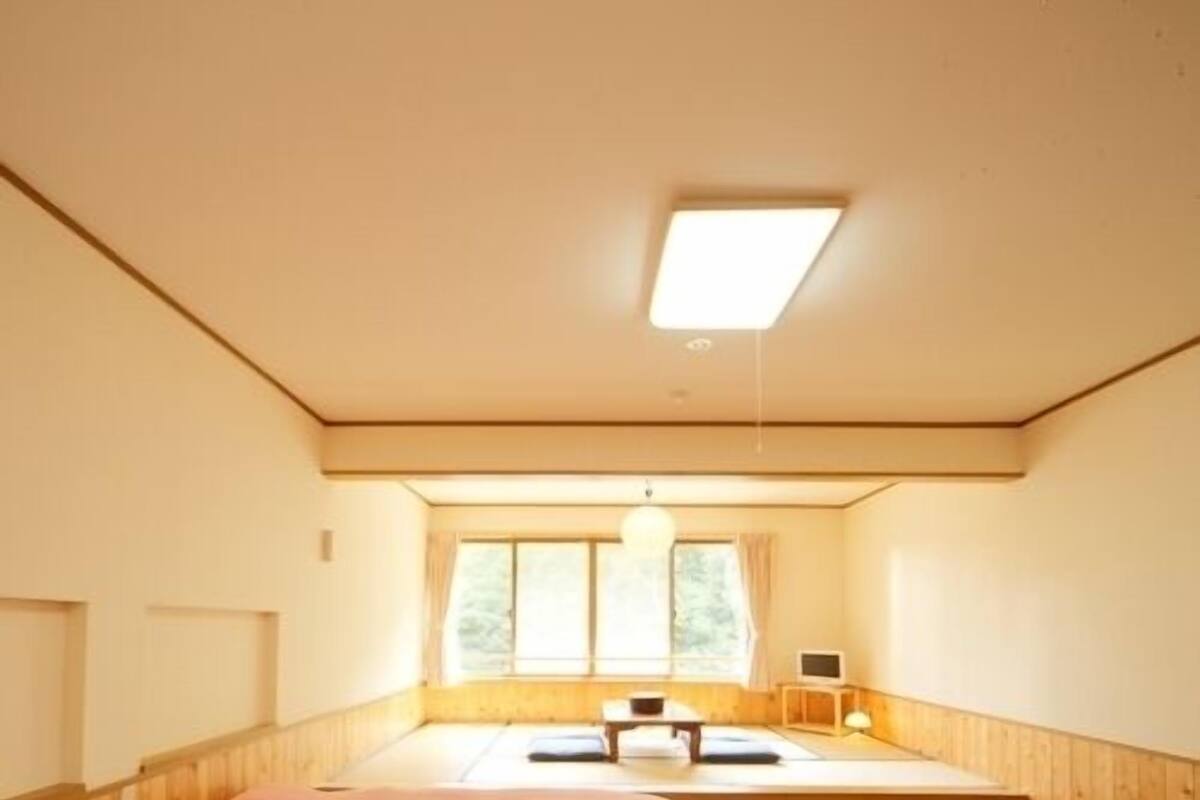 A room with two beds, a window, a desk, and a chair.