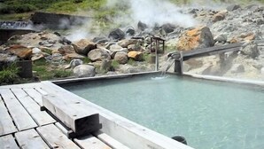 A hot spring area with a wooden deck, a small wooden structure, and a rocky landscape in the background. - Fukenoyu (Kazuno)