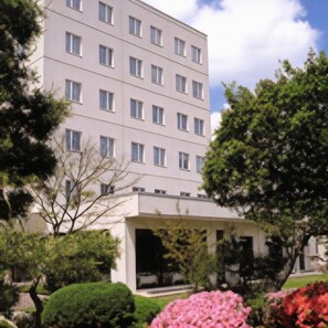 A multi-story hotel with a flat facade, rectangular windows, and a covered entrance.