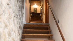 Una escalera de madera con barandilla que lleva a una plataforma con una lámpara.