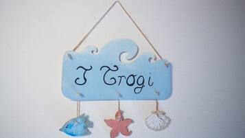 A wall hanging with the name "I Grogi" and decorative fish and starfish.