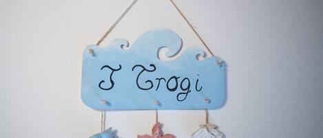 A wall hanging with the name "I Grogi" and decorative fish and starfish.