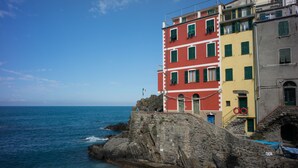 Un edificio costero de varios pisos, con paredes de piedra y vistas al mar.