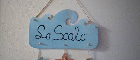 A wall-mounted sign with the text "Lo Scalo" and decorative fish and starfish.