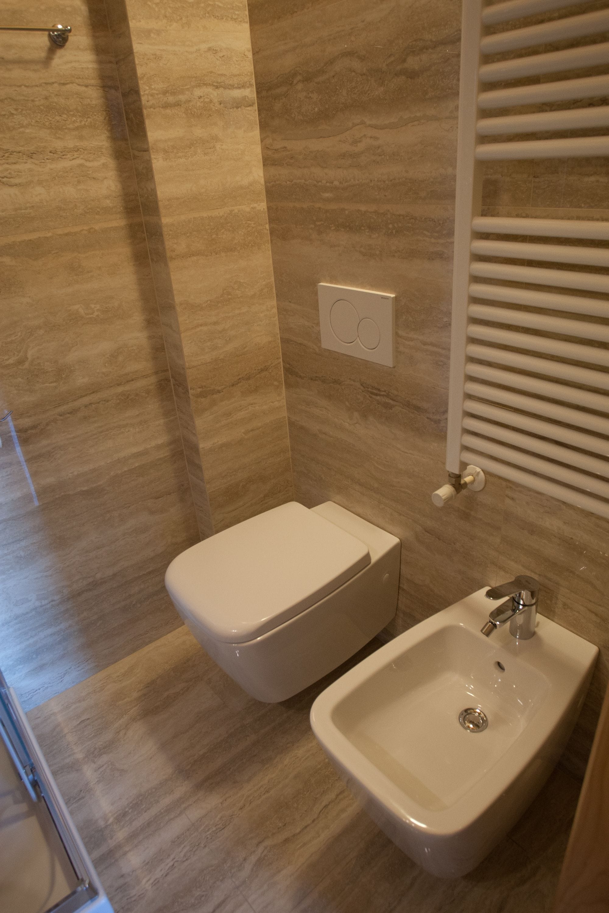 A bathroom with a toilet, sink, and towel rack.