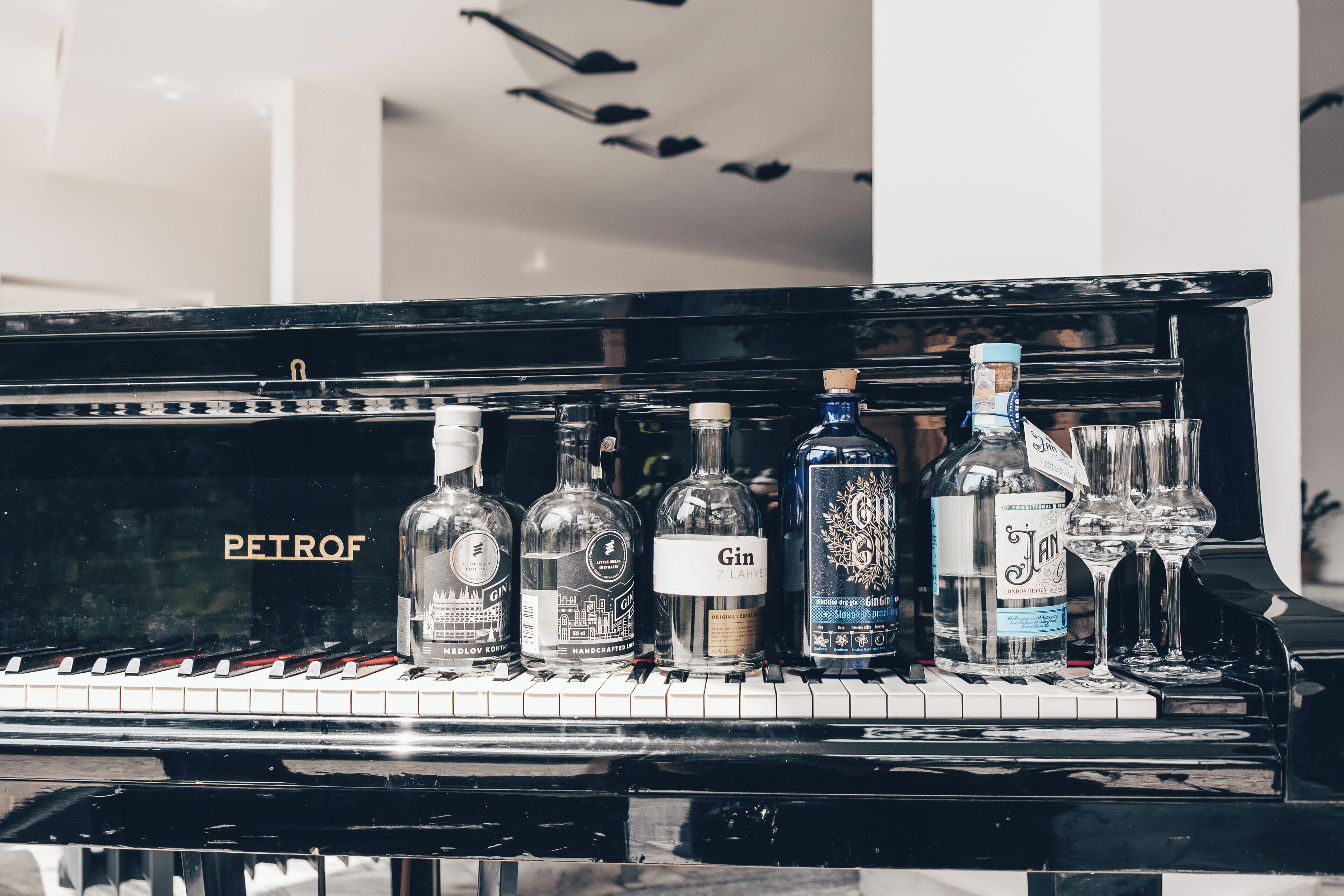 A piano with bottles of alcohol on top.