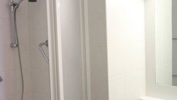 A bathroom with a shower, a sink, and a mirror.
