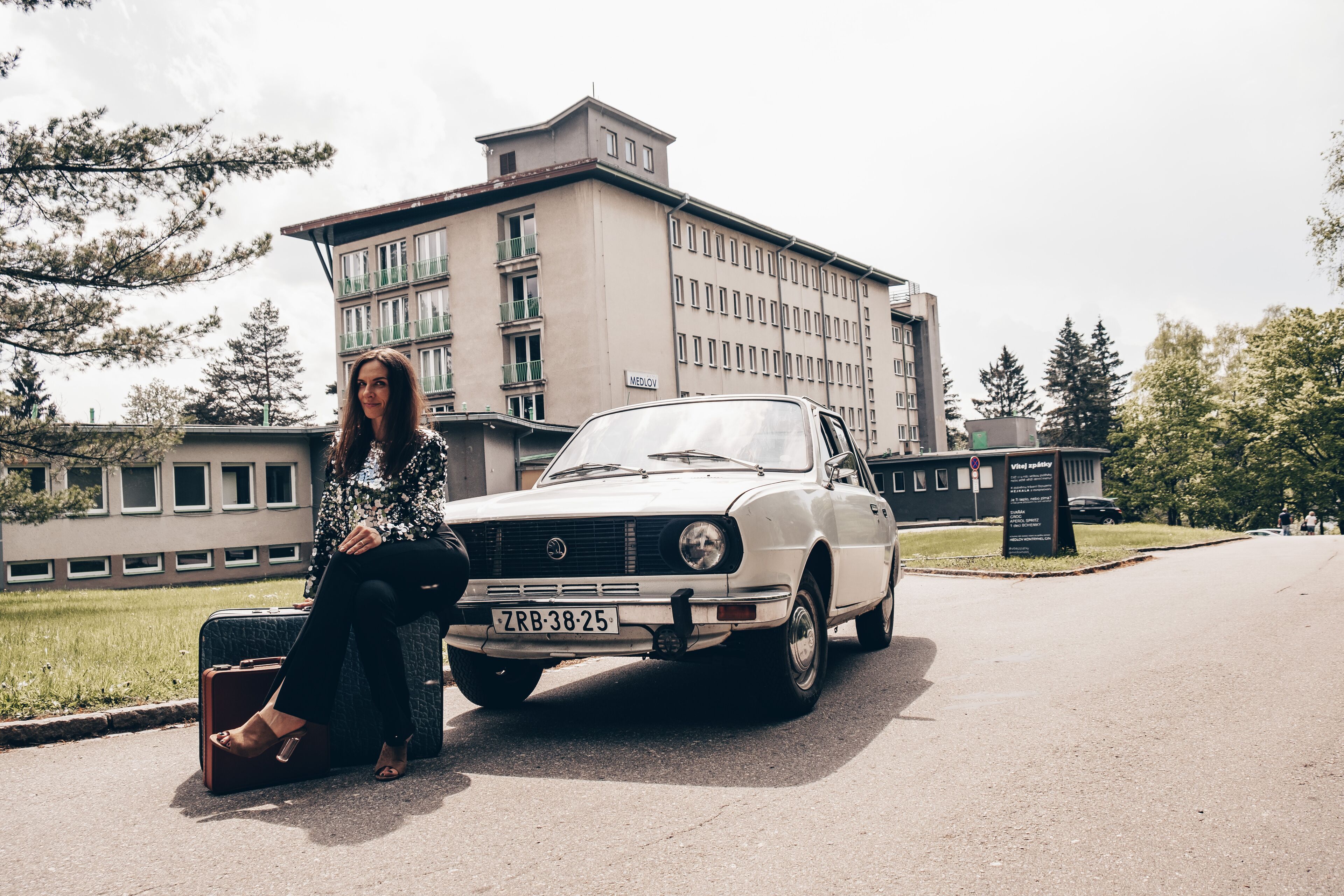 A vintage car parked on a street with a building in the background.