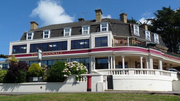 Un bâtiment à deux étages doté d’un balcon et d’une enseigne sur laquelle on peut lire « The Woodvale ».
