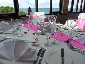Une table dressée pour un repas, avec vue sur la mer.