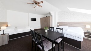 A hotel room with a bed, a desk, a chair, a table, a ceiling fan, and a TV. - Ski Hotel Svoboda nad Upou (Svoboda nad Upou)