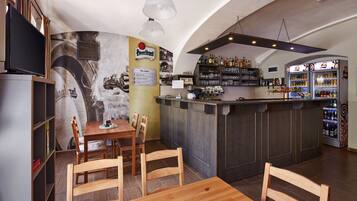 A restaurant with a bar area, wooden chairs, a counter, and a menu board.
