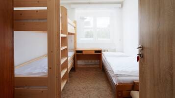 Una habitación con literas, un escritorio y una ventana.