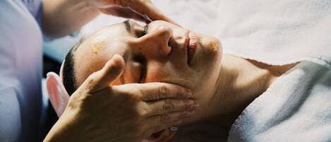 A person lying down with hands on their head, possibly receiving a massage.