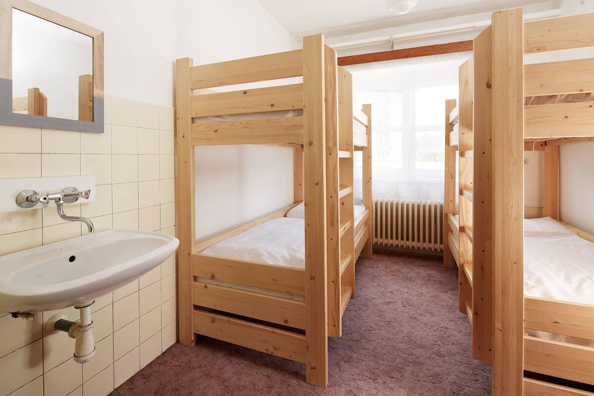 A bunk bed room with a sink and mirror.