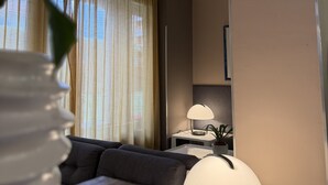 A modern living room with a sofa, a table, and two lamps.