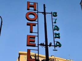Une enseigne d’hôtel avec le mot « HÔTEL » écrit en grandes lettres et une plus petite enseigne avec des caractères cyrilliques.
