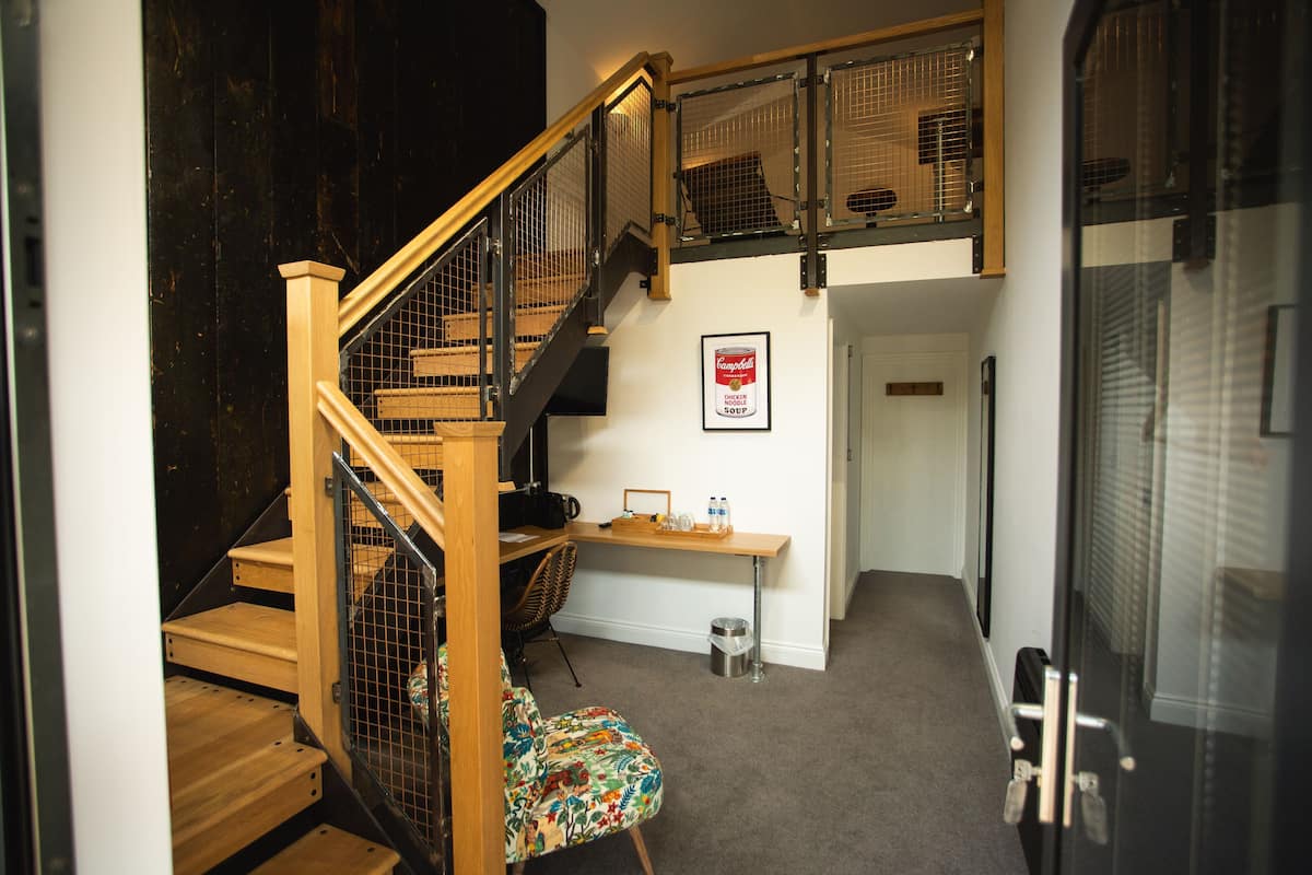 A staircase with wooden steps and metal railings, leading to a second floor.