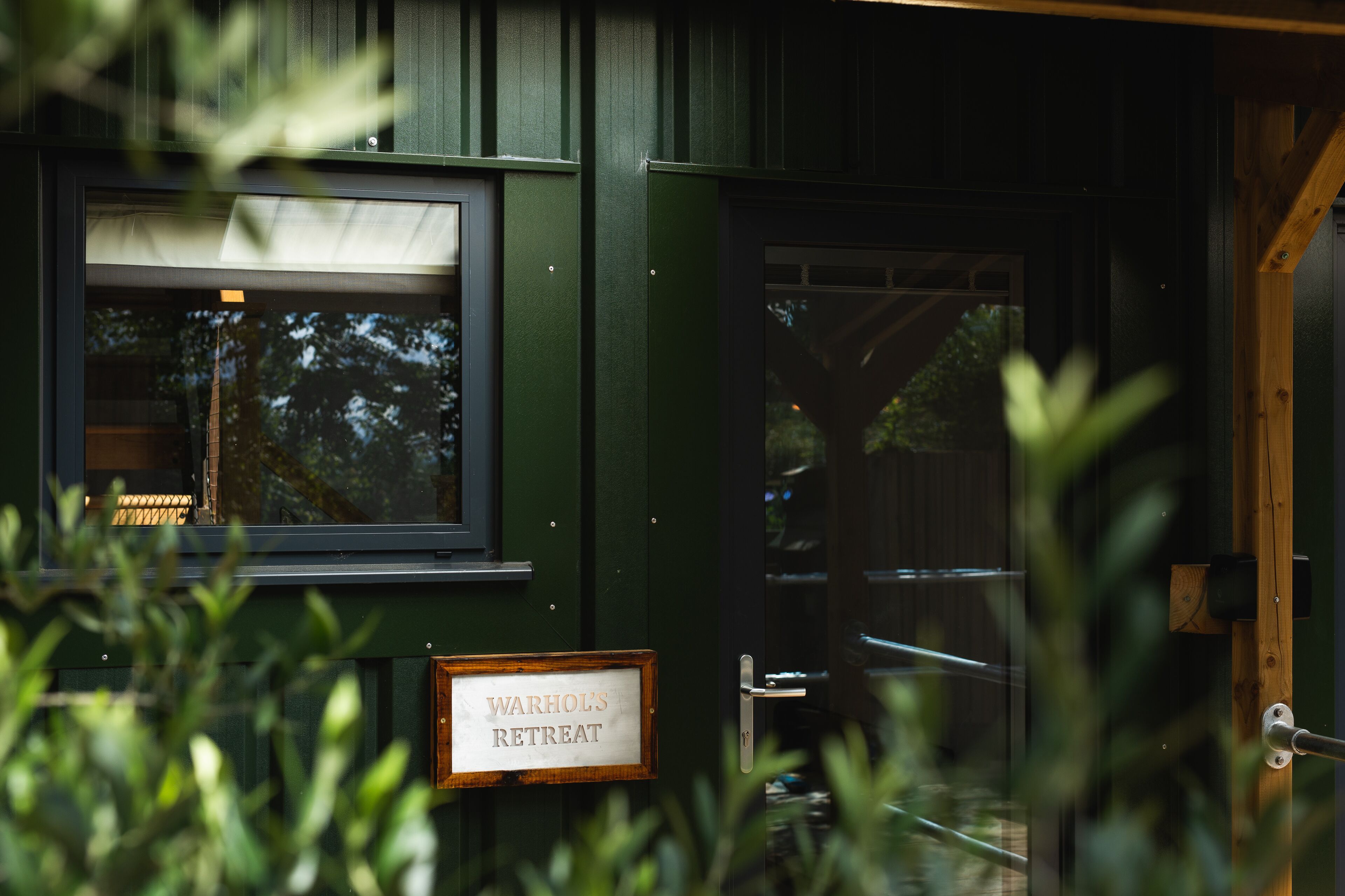 A green building with a sign reading "Warhol's Retreat."