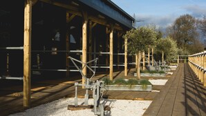 Une structure en bois dotée d’une allée couverte, de rampes en métal et d’un chemin de gravier.