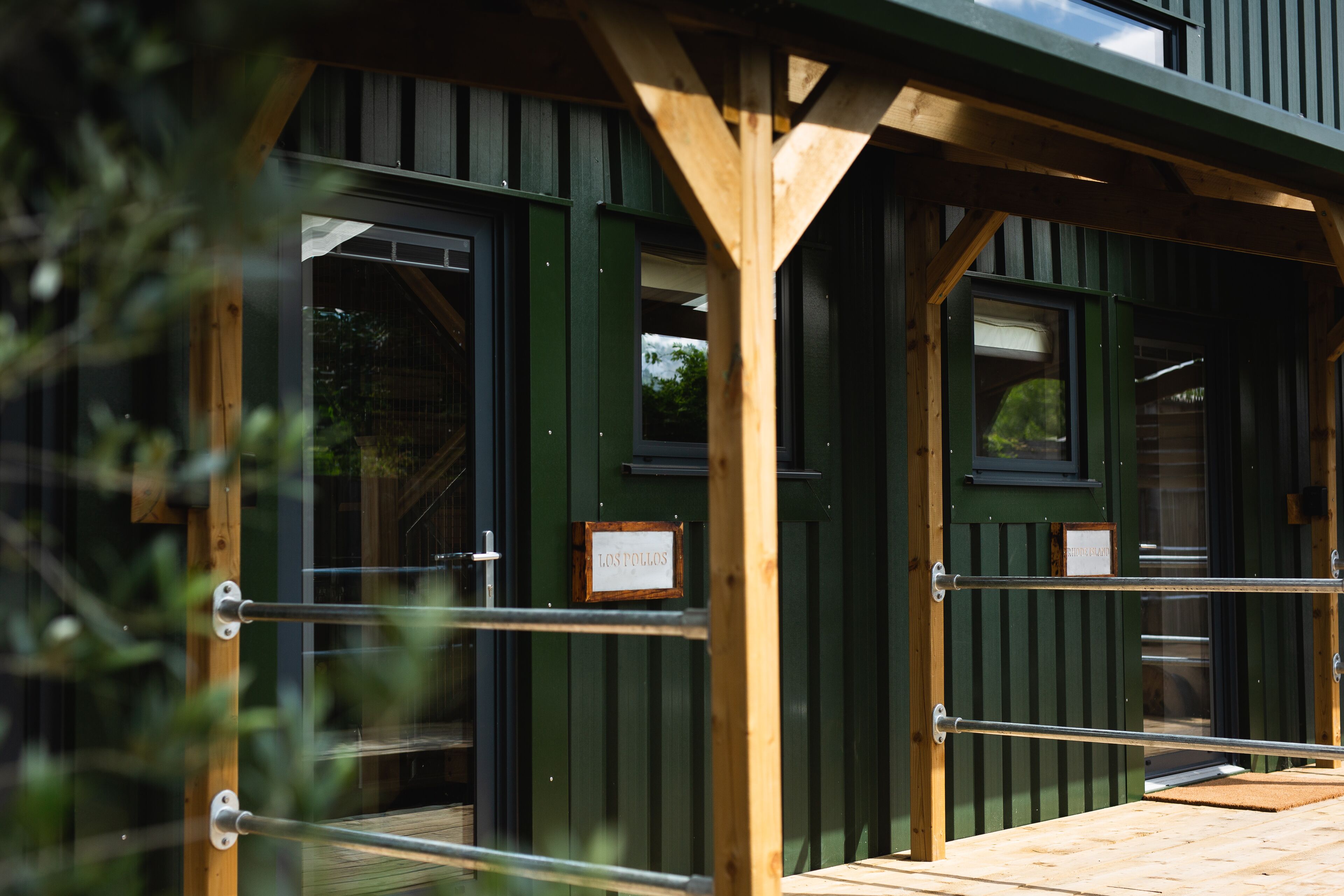 A wooden structure with green panels and a sign reading "LOS POLLOS".