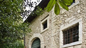 A stone building with a green door and steps leading to a courtyard. - Relais Villa Ambrosetti (Verona)