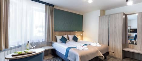 Una habitación de hotel con cama, mesita de noche y espejo.