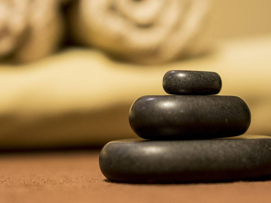 A stack of smooth, dark stones on a flat surface.