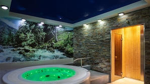 A modern spa area with a hot tub, a mural of a forest scene, and a wooden door. - Krasicki Hotel Resort & SPA (Swieradow-Zdroj)