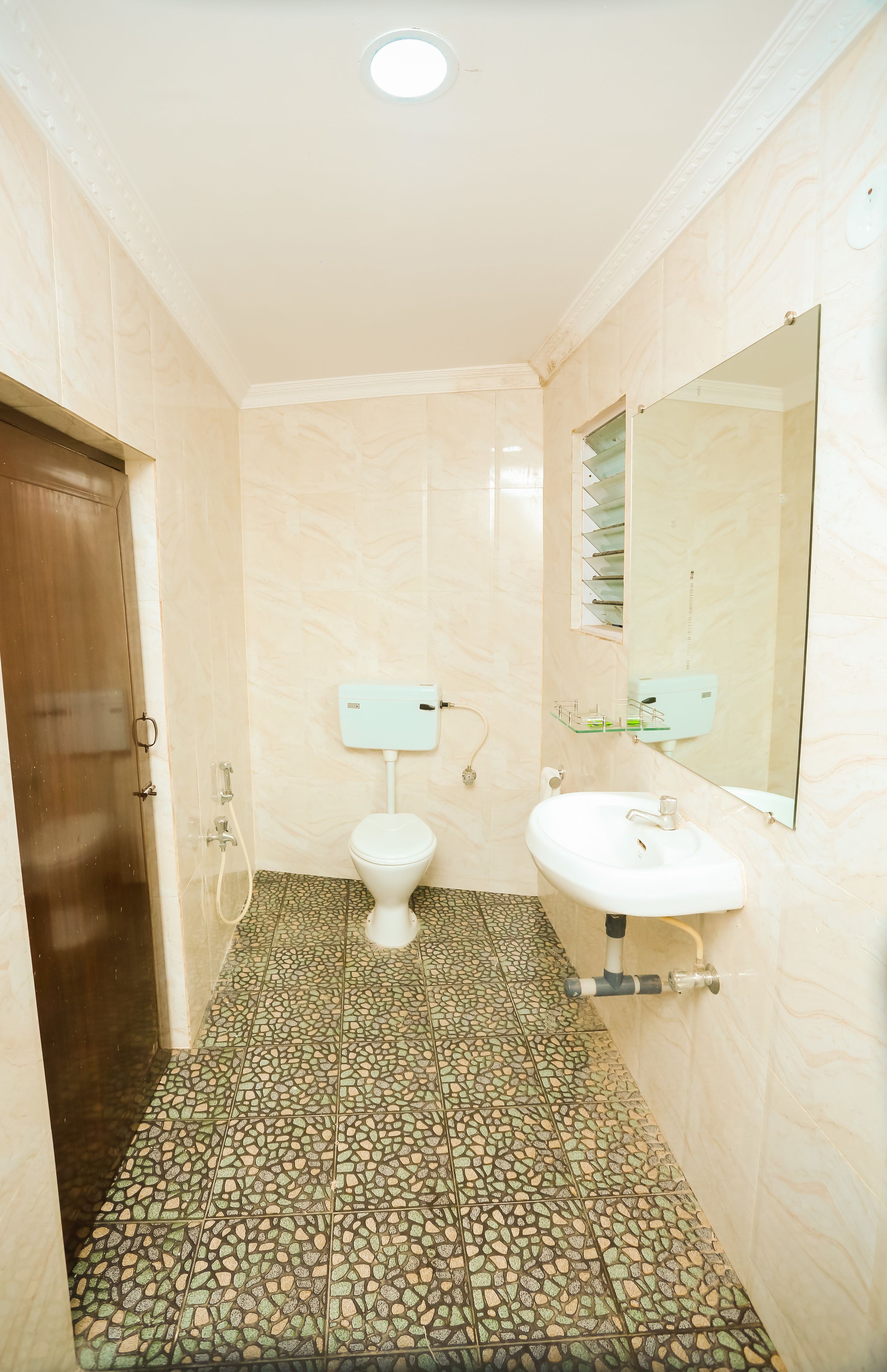 A bathroom with a toilet, sink, and mirror.