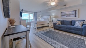 Une chambre moderne avec un lit, des tables de chevet, un bureau et un canapé.