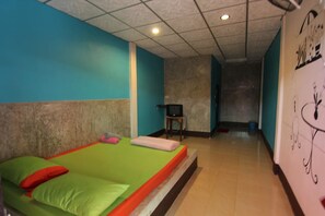 A hotel room with a bed, a chair, and a wall with a floral design. - White Square Rayong (Rayong)