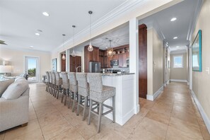 A modern kitchen with a central island, bar seating, and pendant lighting.