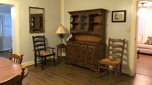 A dining area with a wooden table and chairs, a cabinet with glass doors, and a lamp. - Perfect home in the country (Burton)