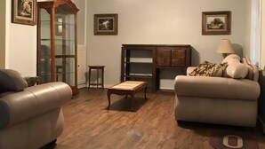 A living room with two sofas, a coffee table, a fireplace, and a ceiling fan. - Perfect home in the country (Burton)